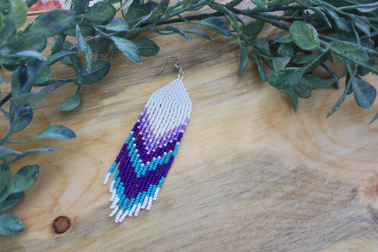 Aretes con cuentas blancas, moradas y turquesas con flecos con punta blanca